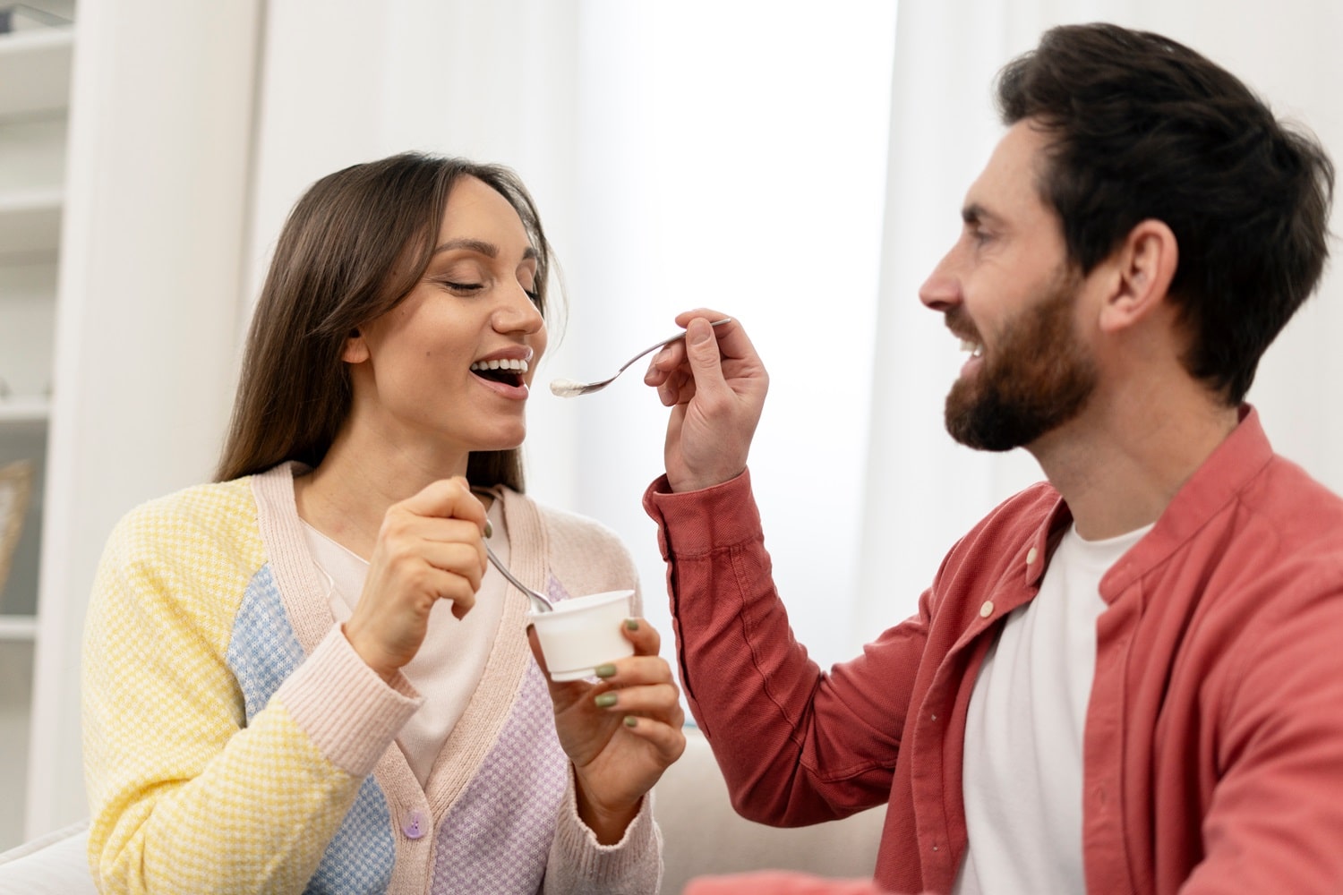 Un homme et une femme mangeant ensemble un yaourt